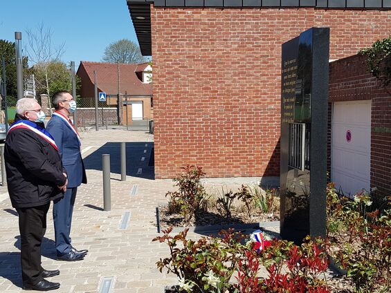 Monsieur le Maire et un élu observent une minute de silence devant la stèle.